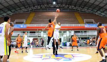 Estudiantes saltando por el balón en un juego de basketball