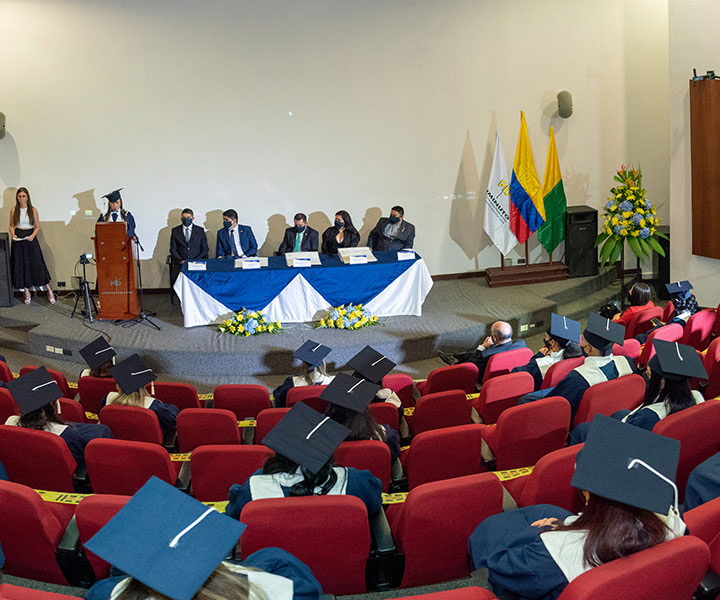 Grados en UNIMINUTO Chinchiná 2021-1 Personas sentadas en auditorio vistiendo togas de color azul para ceremonias de grados