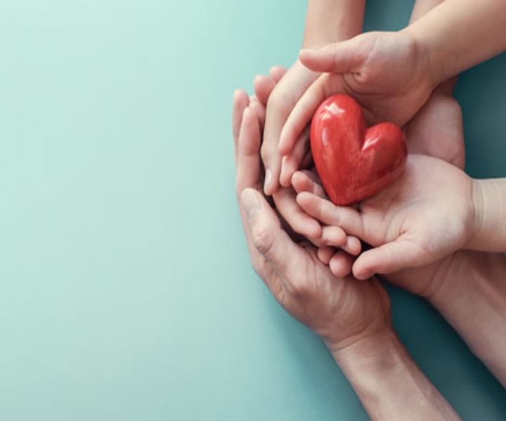 Amor en pandemia manos tomando una figura de corazón