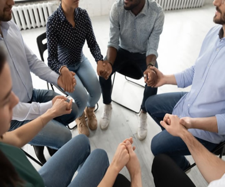 Oración en pandemia grupo de personas en círculo tomándose de las manos