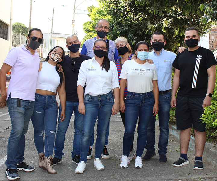 Unidos por La Virginia con voluntad Grupo de 9 voluntarios y beneficiarios, en grupo. Mirando a la cámara en un plano general de pies a cabeza.