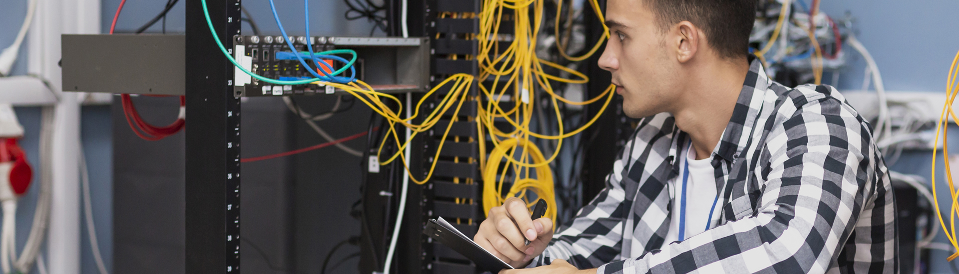 Joven registrando datos junto a conexión redes de telecomunicaciones