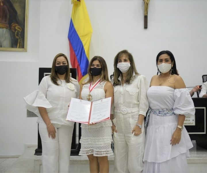 El Centro Regional Barranquilla recibe la Orden de Barlovento Grado de Gran Caballero Cuatro mujeres vestidas de blanco una tiene una medalla y pergamino de reconocimiento