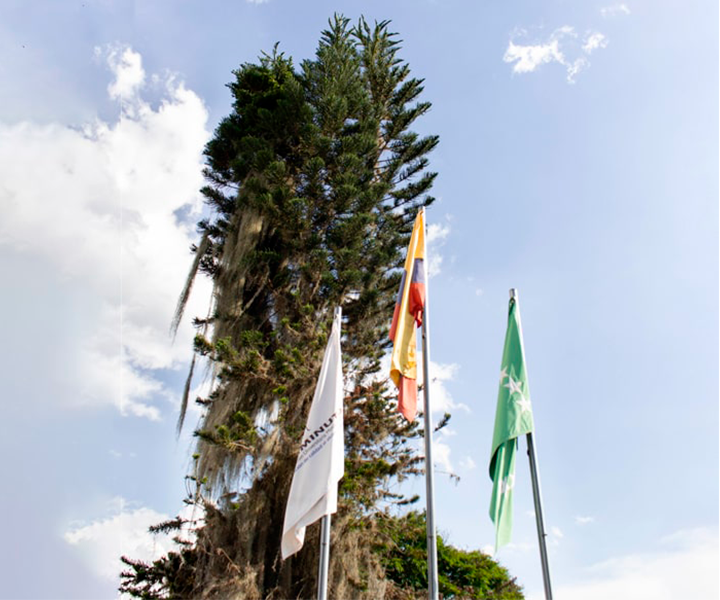 Primer Consejo Superior de sede como rectoría Eje Cafetero Banderas de uniminuto, colombia y risaralda, con paisaje de fondo
