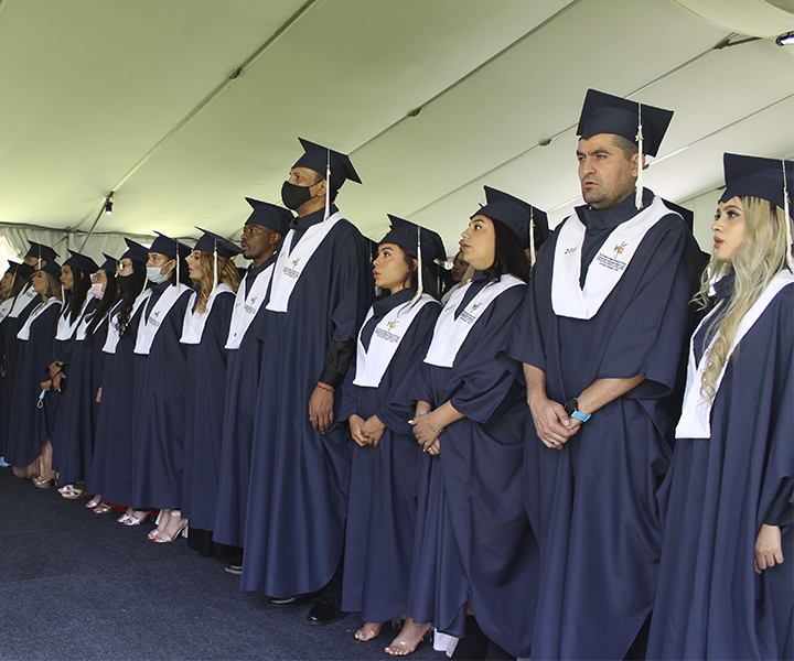 Estudiantes de pie, usando toga y birrete azul Gracias a la voluntad y la determinación, 1002 personas culminaron sus procesos formativos