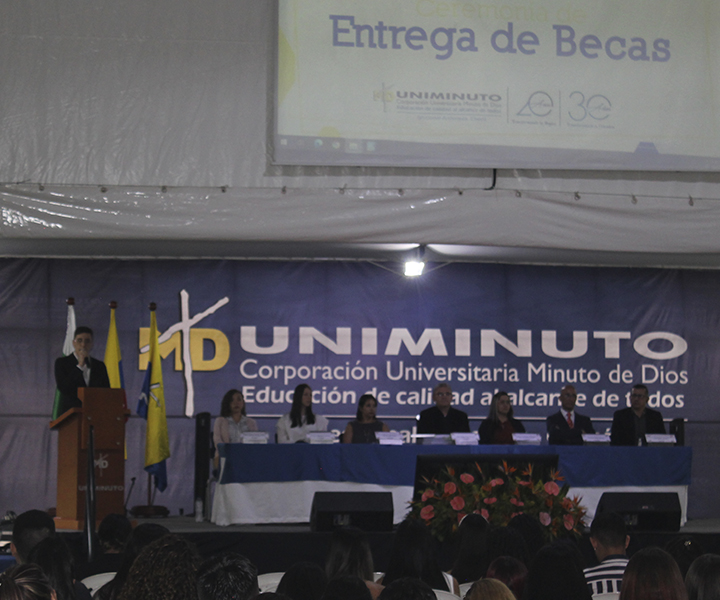 555 apoyos económicos entregados en la Ceremonia de Becas Mesa principal de la ceremonia de entrega de becas UNIMINUTO