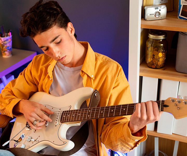 Joven sentado tocando guitarra La noche artística que se tomó las redes sociales de Uniminuto Virtual