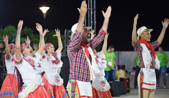 Grupo de baile levantando los brazos al finalizar presentación