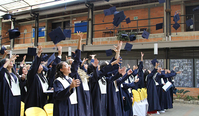 Estudiantes lanzando el birrete.