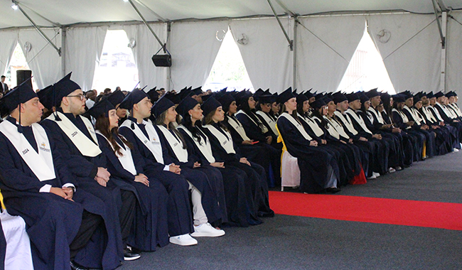 Estudiantes graduados de UNIMINUTO sentados en la ceremonia.