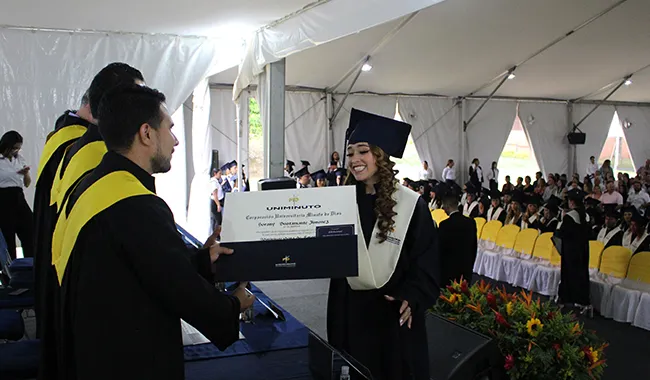Estudiante recibiendo su diploma de carrera profesional en ceremonia. 