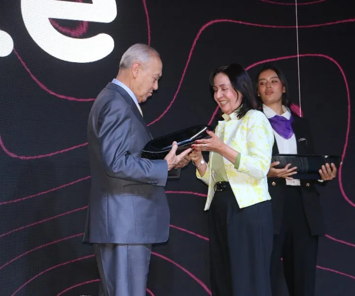 Margarita Pérez, directora de proyección social recibiendo el reconocimiento