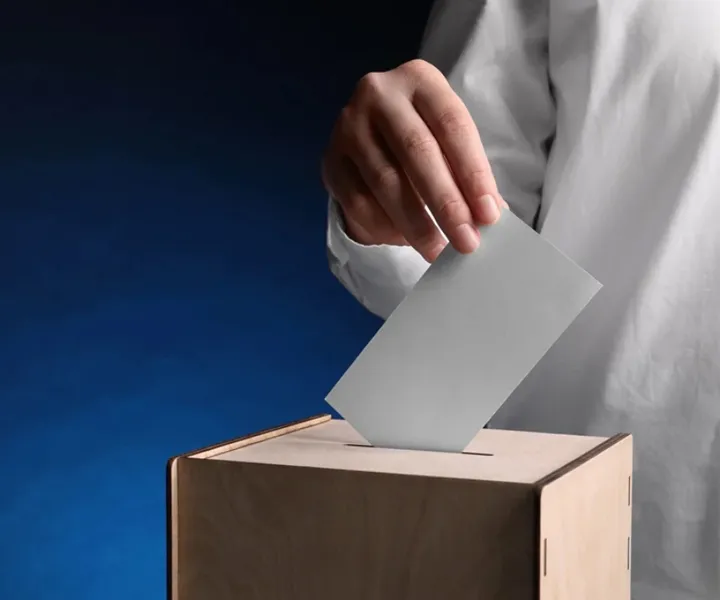 mano ingresando el voto en la urna en jornada electoral