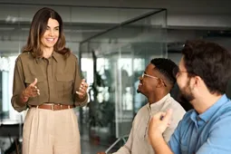 Ejecutiva dando un charla a dos personas de su equipo