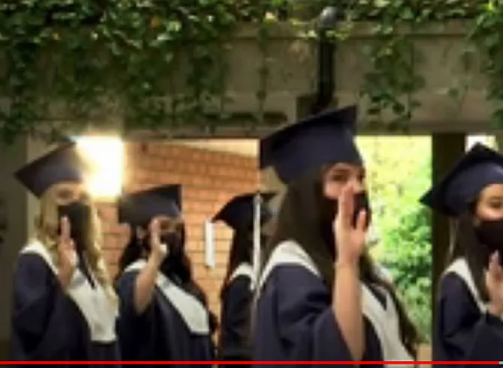 Graduados de Antioquia con toga, birrete y tapabocas