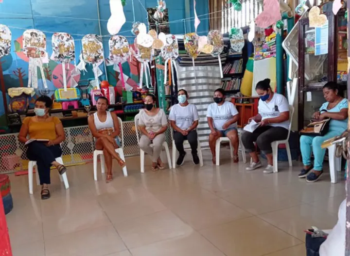 Mujeres en mesa redonda atienden a las explicaciones y acomapañamiento del voluntariado
