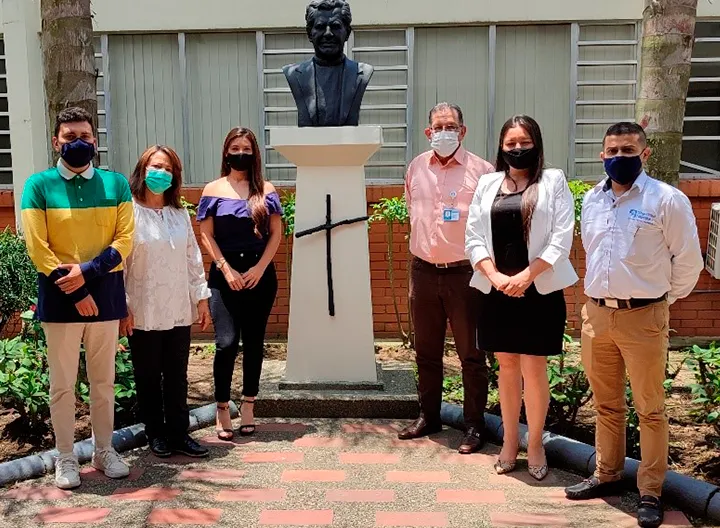 Fotografía de los asistentes al desayuno, junto al busto del padre rafael garcía herreros