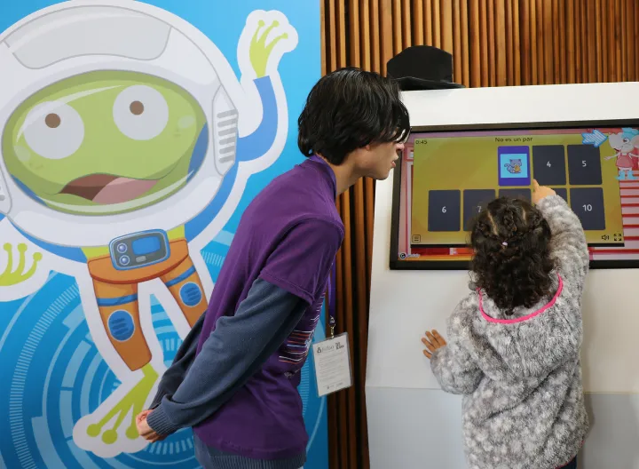 Estudiante UNIMINUTO guiando a niña participante de la FILBO