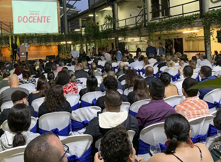 Docentes reunidos en el recinto escuchando un discurso