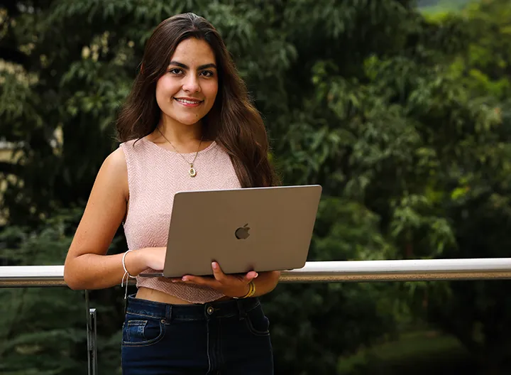 estudiante con computador en la mano